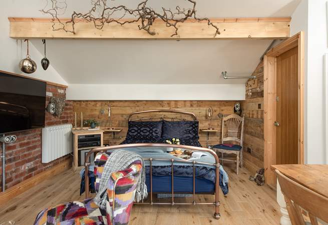 The luxurious bed has a fabulous brass bedstead, giving the cabin a rustic and industrial, yet chic look and feel. 