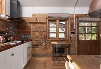 The microwave is cleverly integrated into the handcrafted kitchen, where lots of recycled materials have been carefully incorporated. 