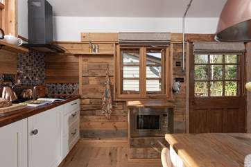 The microwave is cleverly integrated into the handcrafted kitchen, where lots of recycled materials have been carefully incorporated.