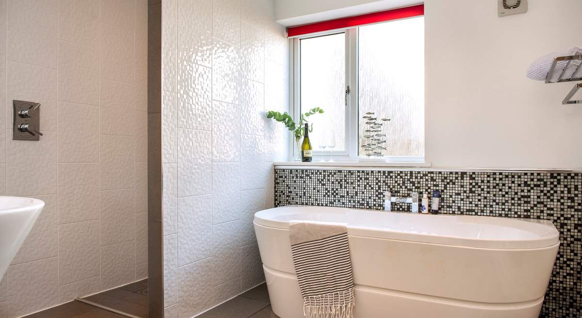 The glamorous family bathroom has a separate shower and a luxurious free-standing bath.