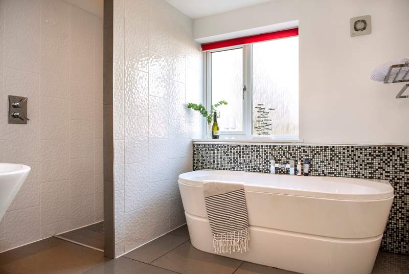 The glamorous family bathroom has a separate shower and a luxurious free-standing bath.