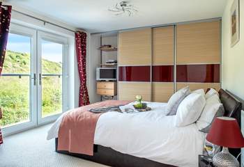 A wonderfully light and airy bedroom, thanks to the large double doors.