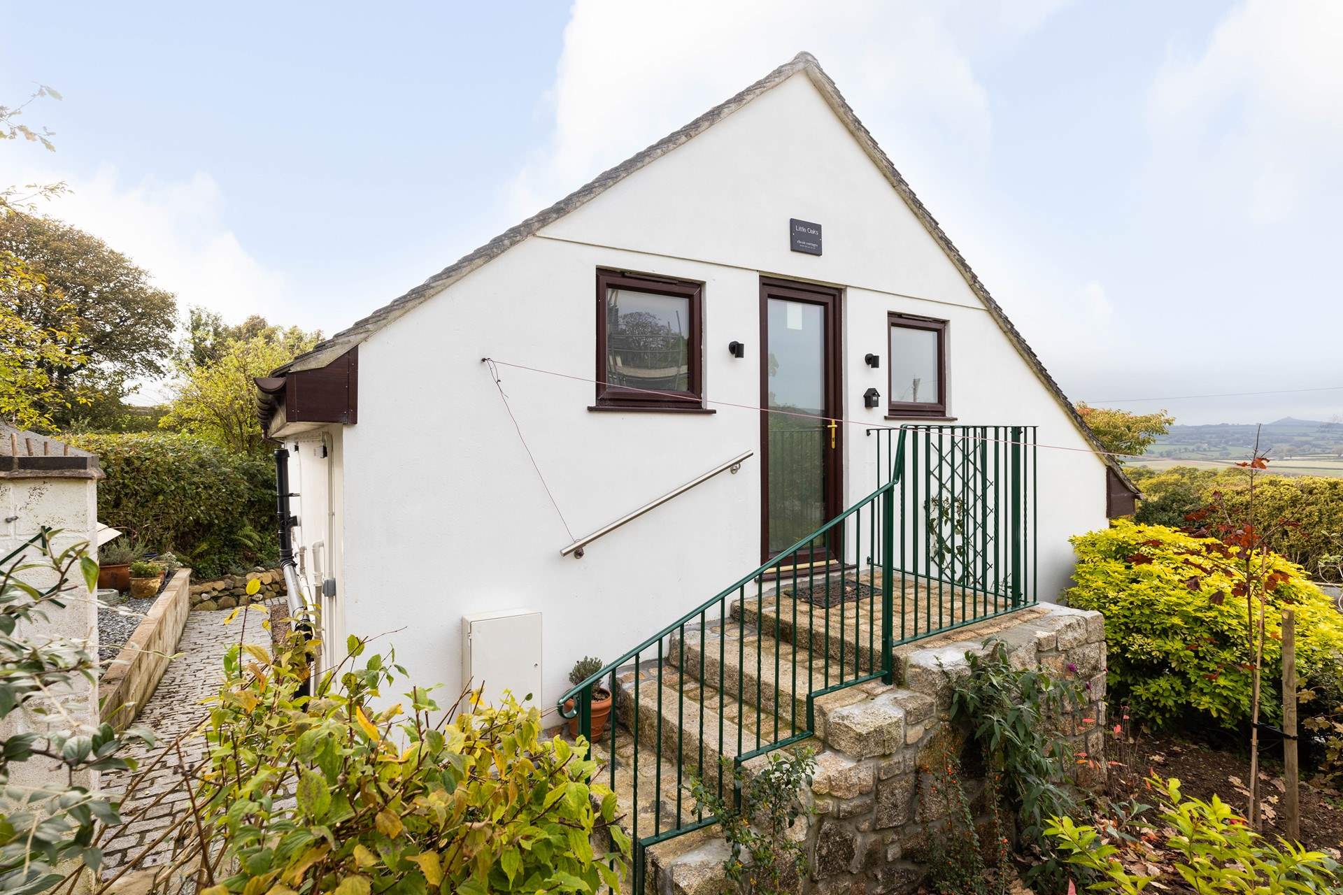 The path from the parking area leads to the front door of Little Oaks at the top of the steps.