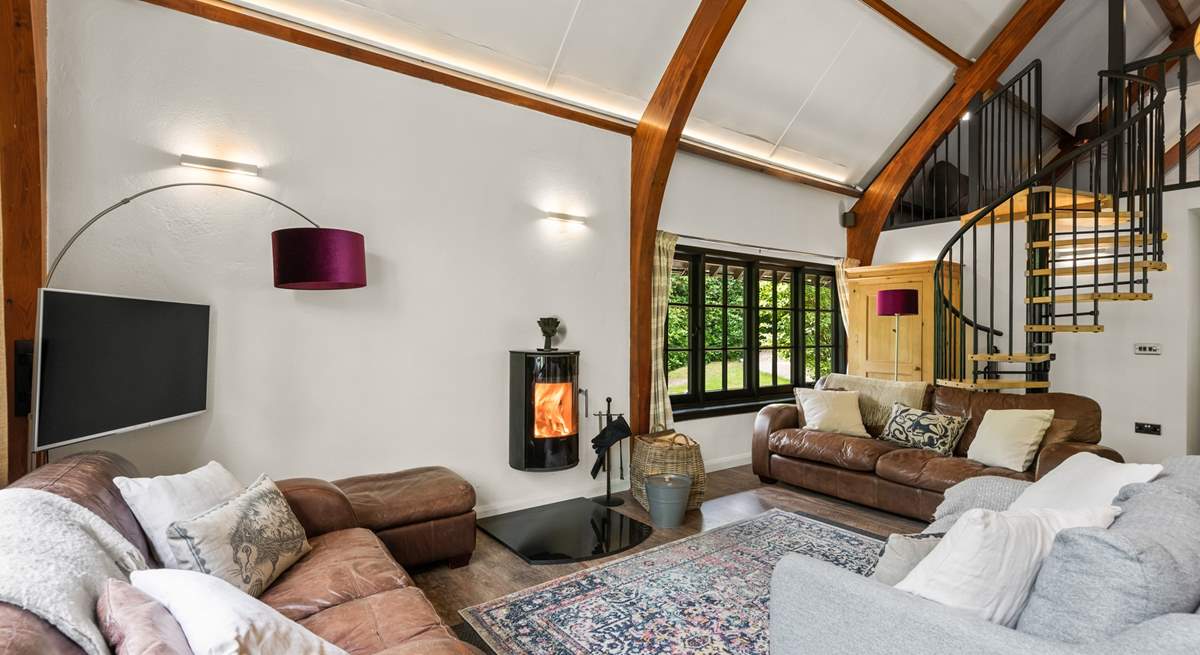 The open plan living space is light and bright with characterful beamed ceilings and windows overlooking the surrounding peaceful woodland.