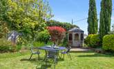 The small table and chairs (8 available) at the bottom of the garden make al fresco dining a dream. - Thumbnail Image