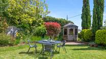 The small table and chairs (8 available) at the bottom of the garden make al fresco dining a dream.