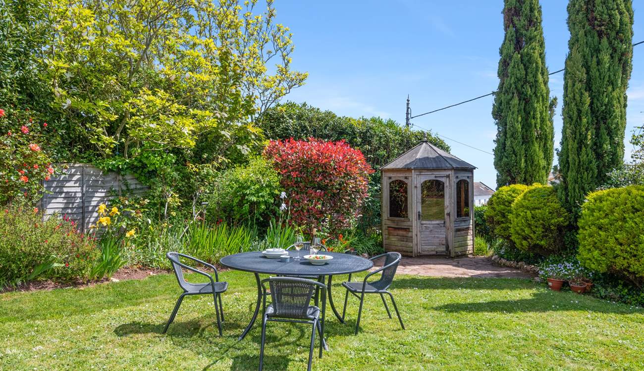 The small table and chairs (8 available) at the bottom of the garden make al fresco dining a dream.