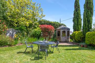 The small table and chairs (8 available) at the bottom of the garden make al fresco dining a dream.