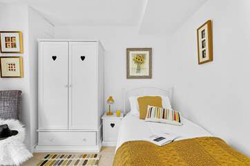 The charming single bedroom is as pretty as a picture and has gorgeous artwork by the clever owner adorning the walls.