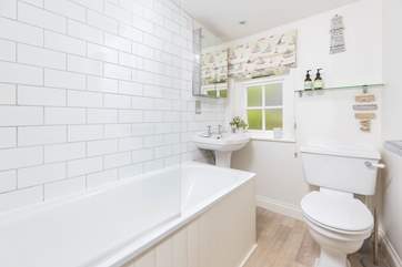 The nautical theme flows into the bathroom, with bath and shower over.
