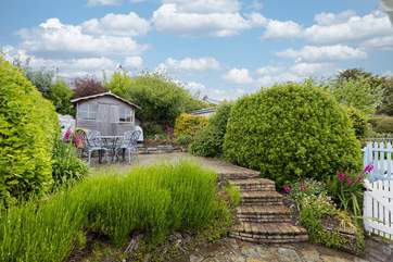 Steps lead up to a secluded patio at the rear of the cottage, the perfect place for al fresco dining.