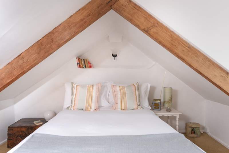 Beautiful exposed wooden beams intimately enclose the main bedroom's double bed.