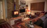 The cosy sitting-room with warming wood-burner is the perfect place to relax at anytime of year. - Thumbnail Image