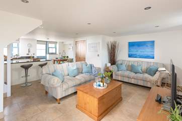 The decor of the open plan living-room perfectly complements the coastal location
