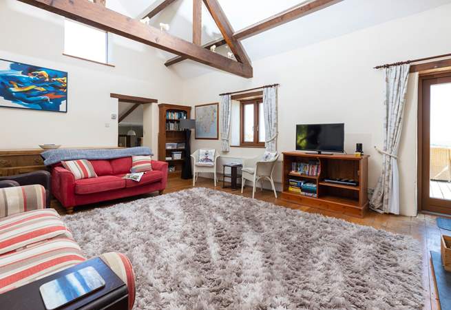 The sitting-room on the ground floor is super cosy and characterful with exposed beams and comfy sofas.