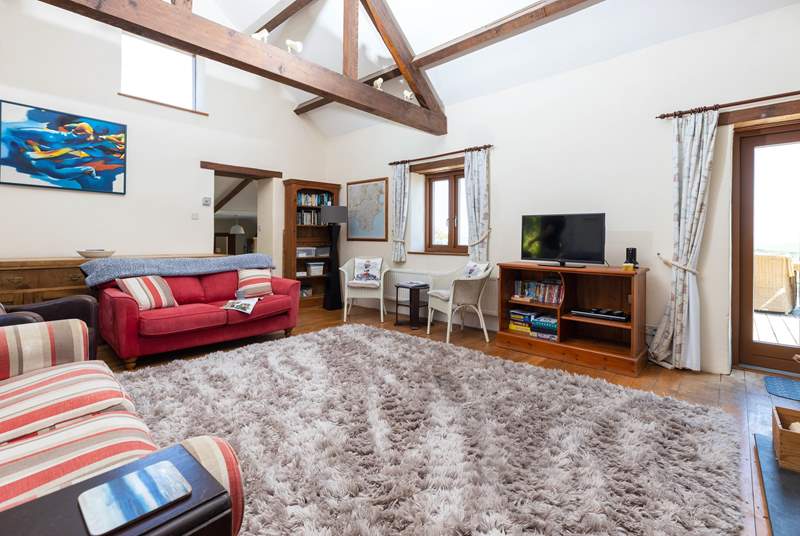 The sitting-room on the ground floor is super cosy and characterful with exposed beams and comfy sofas.