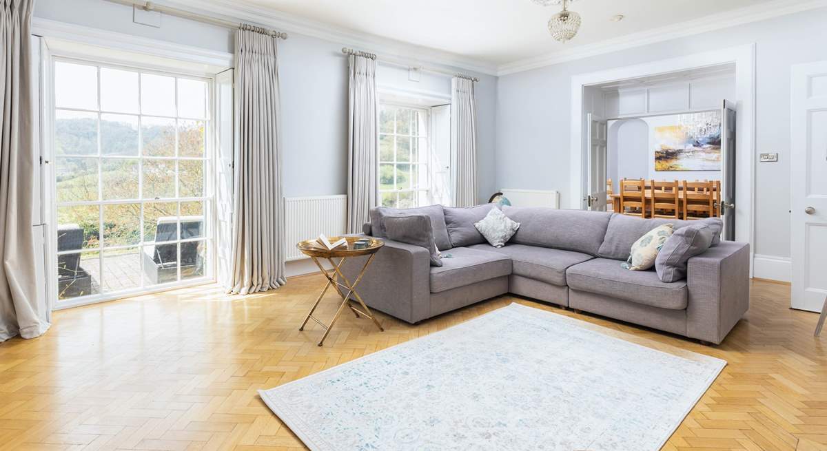 Natural light floods into the main sitting-room through the stunning windows.