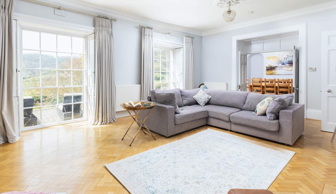 Natural light floods into the main sitting-room through the stunning windows.
