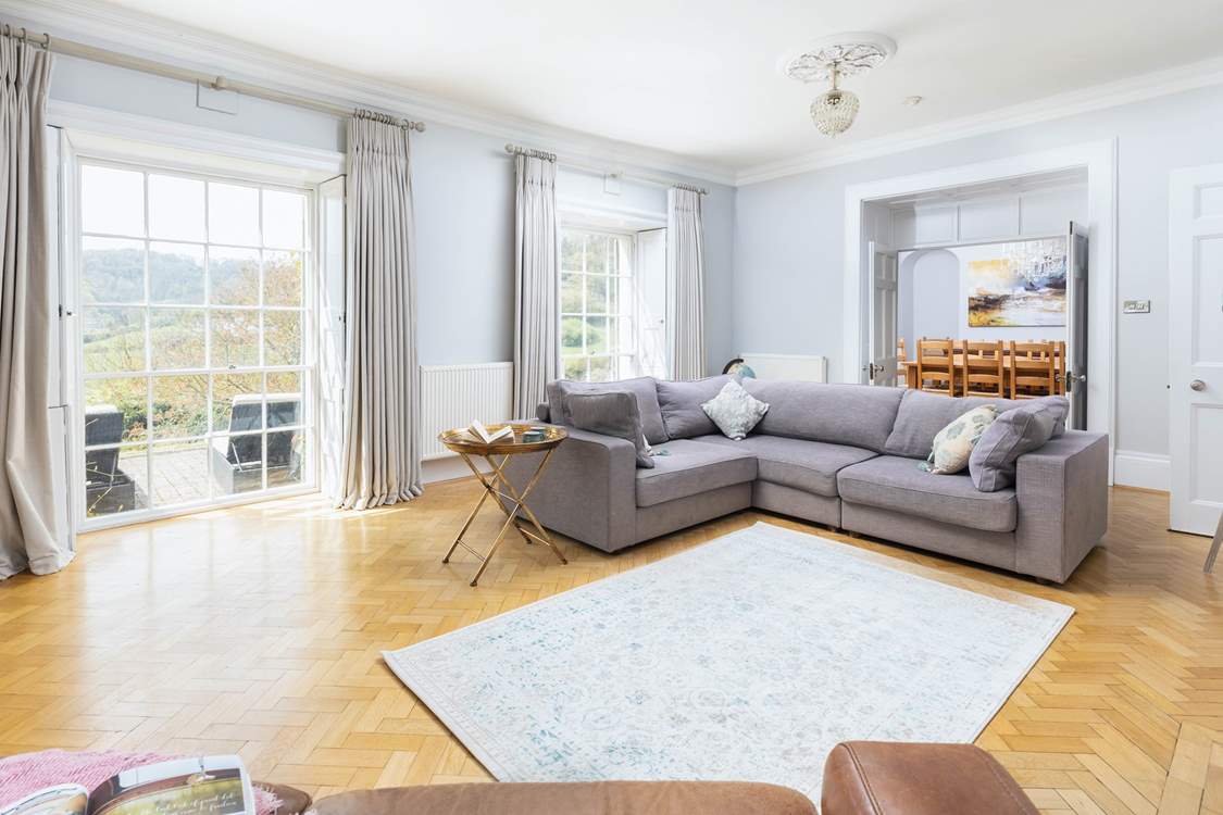 Natural light floods into the main sitting-room through the stunning windows.