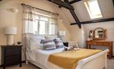 The spacious double bedroom sits on the first floor and the exposed beams add to the overall character and charm - Thumbnail Image