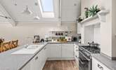 A crisp modern kitchen sits at the end of the space. - Thumbnail Image