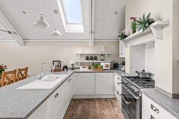 A crisp modern kitchen sits at the end of the space.