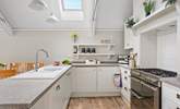 A crisp modern kitchen sits at the end of the space. - Thumbnail Image