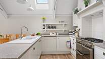 A crisp modern kitchen sits at the end of the space.