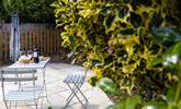 There's a secluded patio at the rear of The Wickets with a bistro table and chairs. - Thumbnail Image