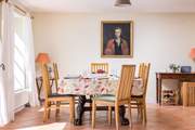 A beautifully crafted dining-table sits at the end of the space.