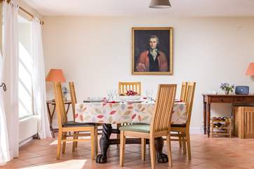 A beautifully crafted dining-table sits at the end of the space.