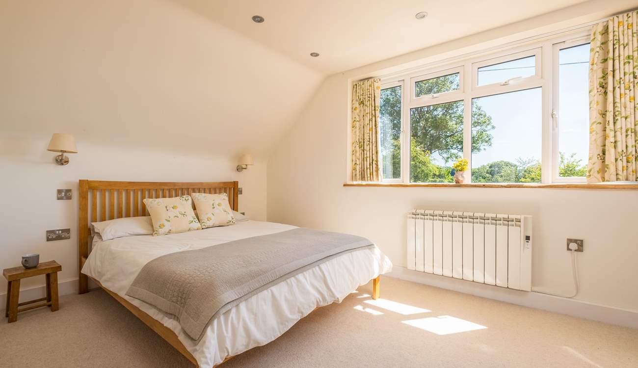 The light and spacious main bedroom has an en suite bathroom. 