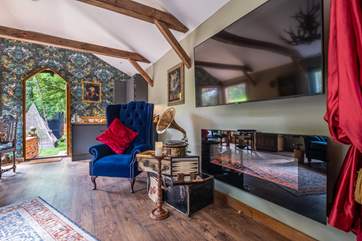 The Smart TV and feature fireplace accompany the quirky, opulent decor.