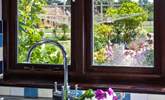 Gaze out the kitchen window to the owners' beautiful garden, which is filled with colourful flowers. - Thumbnail Image