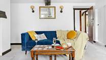 Snuggle up in front of the fire on the lavish velvet sofas, the kitchen and dining-room are accessed through the door to the right.