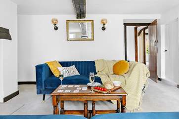 Snuggle up in front of the fire on the lavish velvet sofas, the kitchen and dining-room are accessed through the door to the right.