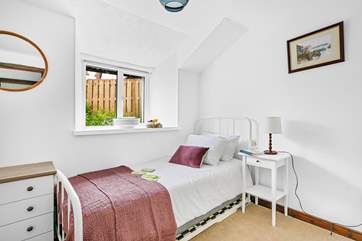 A delightful single bed is accompanied by a handy trundle bed in bedroom one.