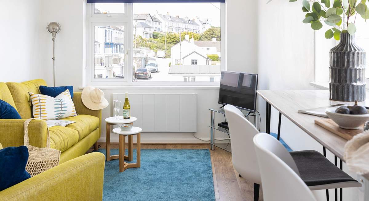 Decorated in nautical whites and blues, the yellow sofa bring a splash of colour.