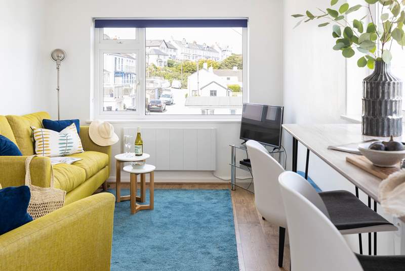Decorated in nautical whites and blues, the yellow sofa bring a splash of colour.