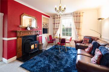 Cosy up around the luxurious wood-burning stove in the welcoming sitting-room.