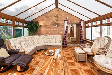 The inviting conservatory provides the ideal spot to enjoy a warming cup of coffee in the morning.