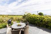 The secluded patio at the rear of Willow's Place overlooks a pretty meadow towards Gull rock and beyond.