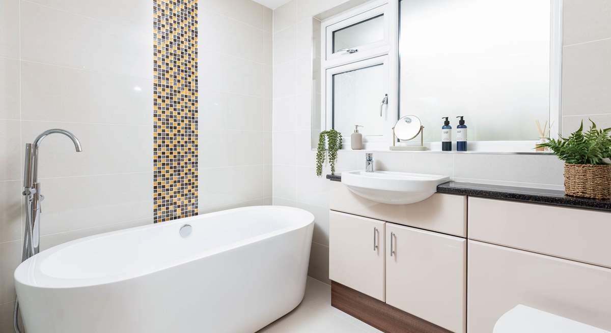 The swish family bathroom has a gorgeous free-standing bath and a walk-in shower.