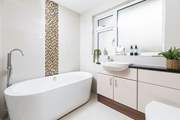 The swish family bathroom has a gorgeous free-standing bath and a walk-in shower.