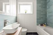 The stylish family bathroom has a bath with fitted shower.