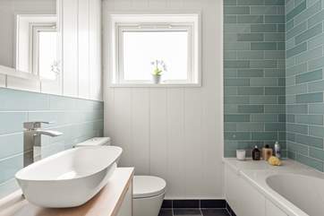 The stylish family bathroom has a bath with fitted shower.