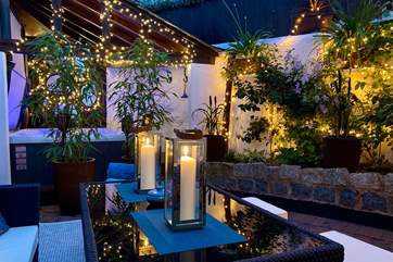 As the sun sets, the back garden transforms into a nighttime delight.