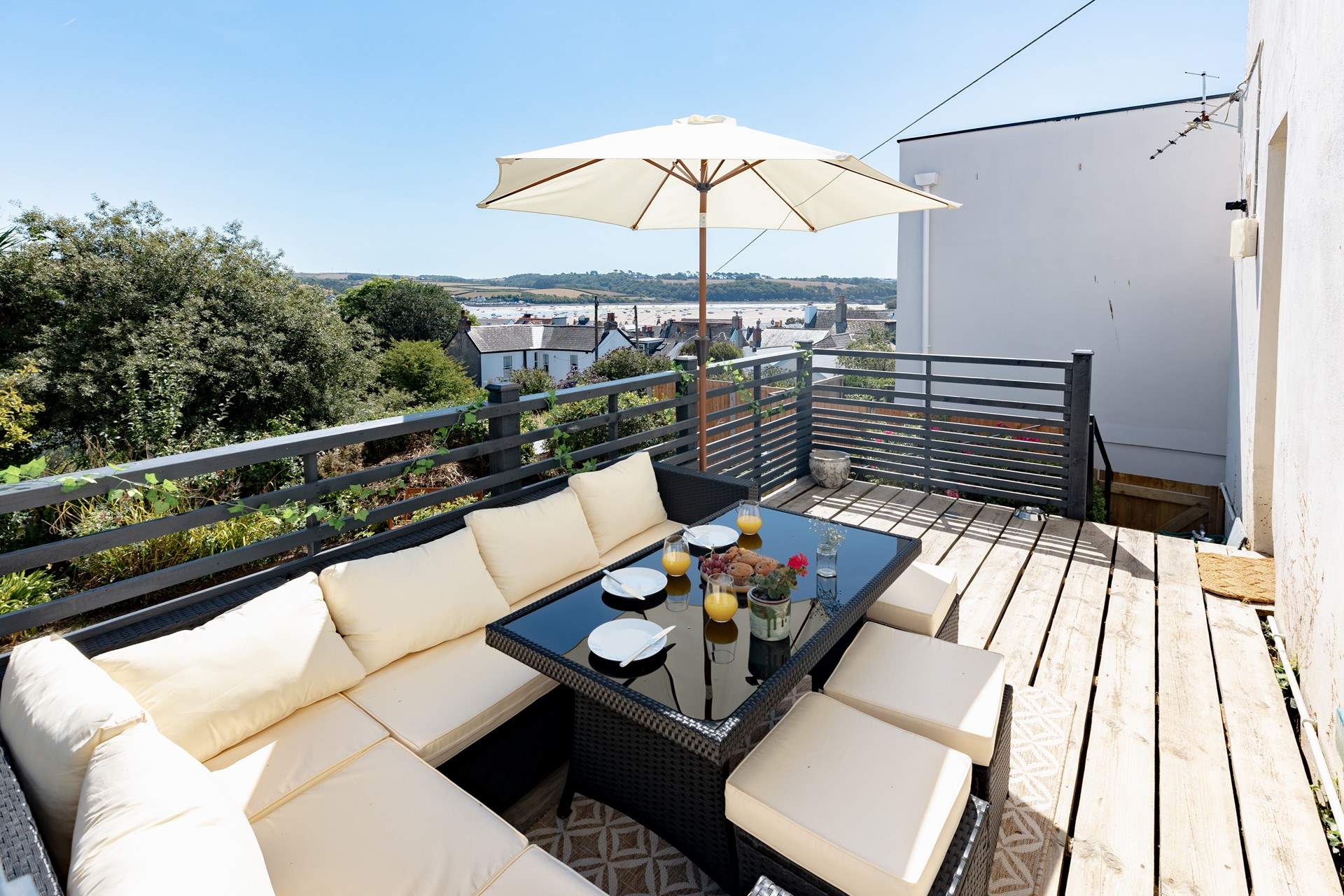 Welcome to Sunnyside the view awaits your arrival! Enjoy al fresco dining in this fabulous spot on the raised deck. This sofa has been moved to the lower patio and a new teak table and chairs are positioned here.