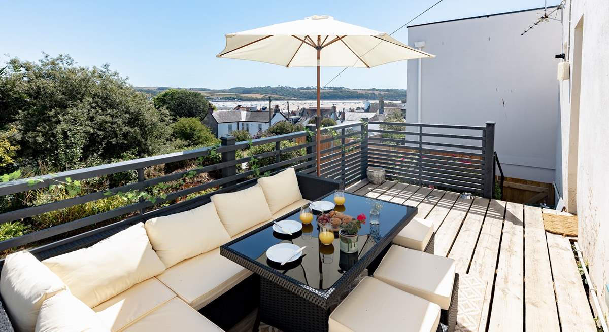 Welcome to Sunnyside the view awaits your arrival! Enjoy al fresco dining in this fabulous spot on the raised deck. This sofa has been moved to the lower patio and a new teak table and chairs are positioned here.