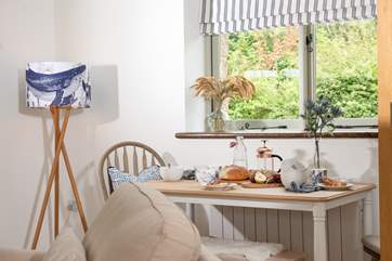 An intimate dining-table is tucked into the corner of the space.